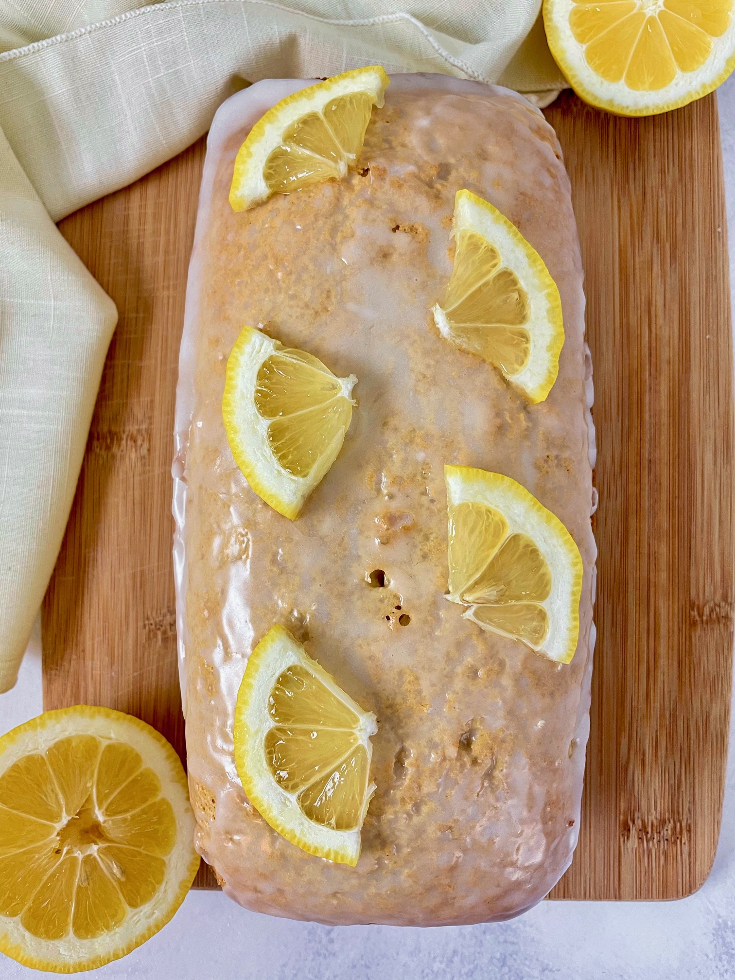 healthy lemon loaf with lemon glaze and lemon slices on top