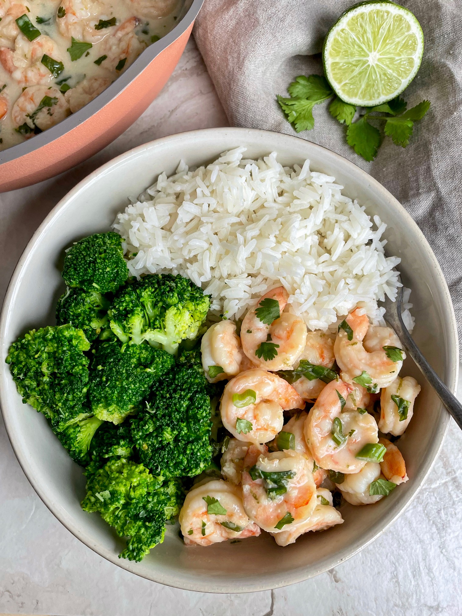 a bowl of creamy coconut shrimp with rice and broccoli