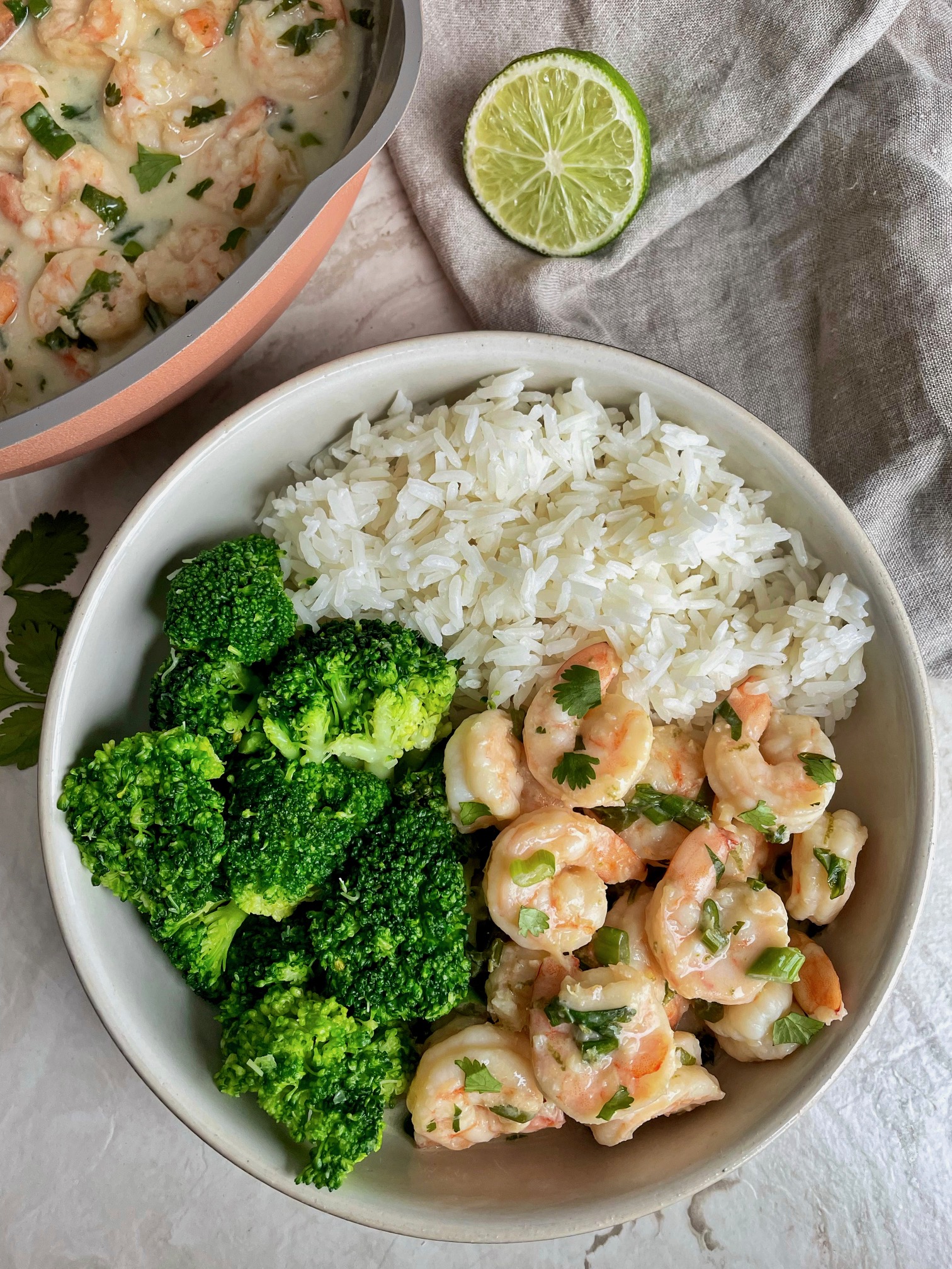 a final shot of creamy coconut shrimp in a bowl with rice and broccoli