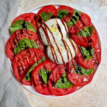 the completed burrata caprese dish with balsamic drizzle.