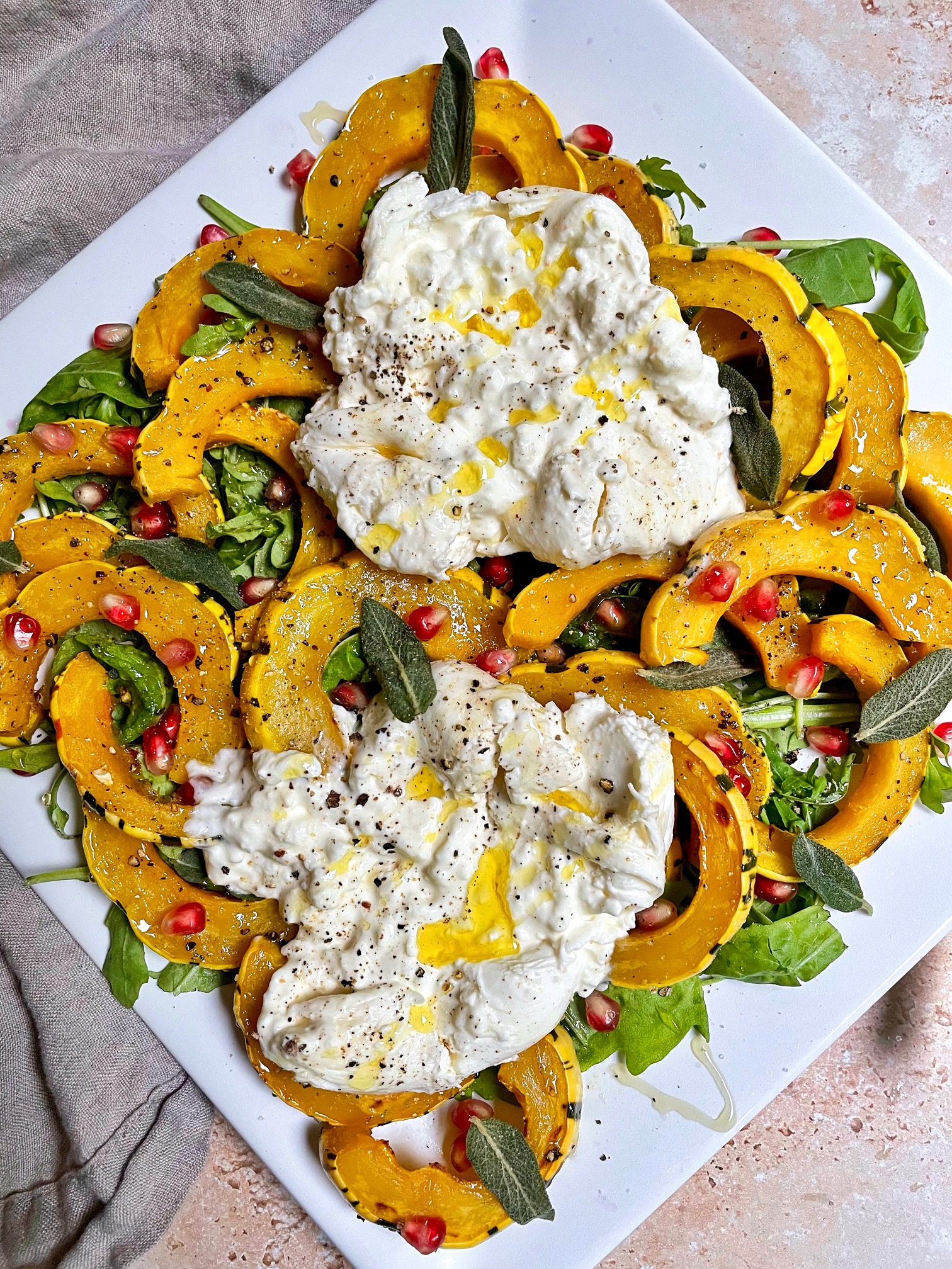 roasted delicata squash and burrata on a bed of arugula and drizzled with olive oil and honey.