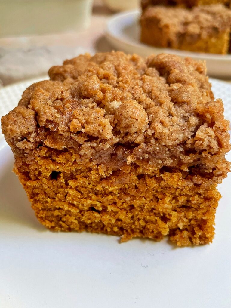 a close up shot of a piece of pumpkin coffee cake on a plate.