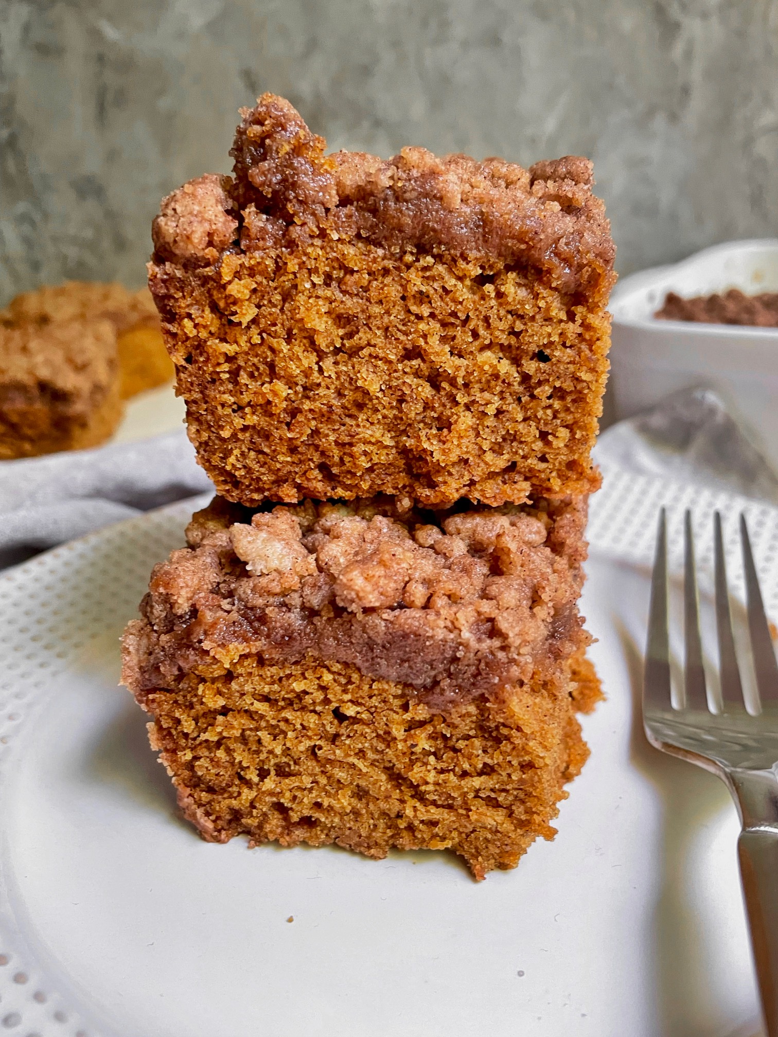 Two pieces of pumpkin coffee cake stacked on top of each other.