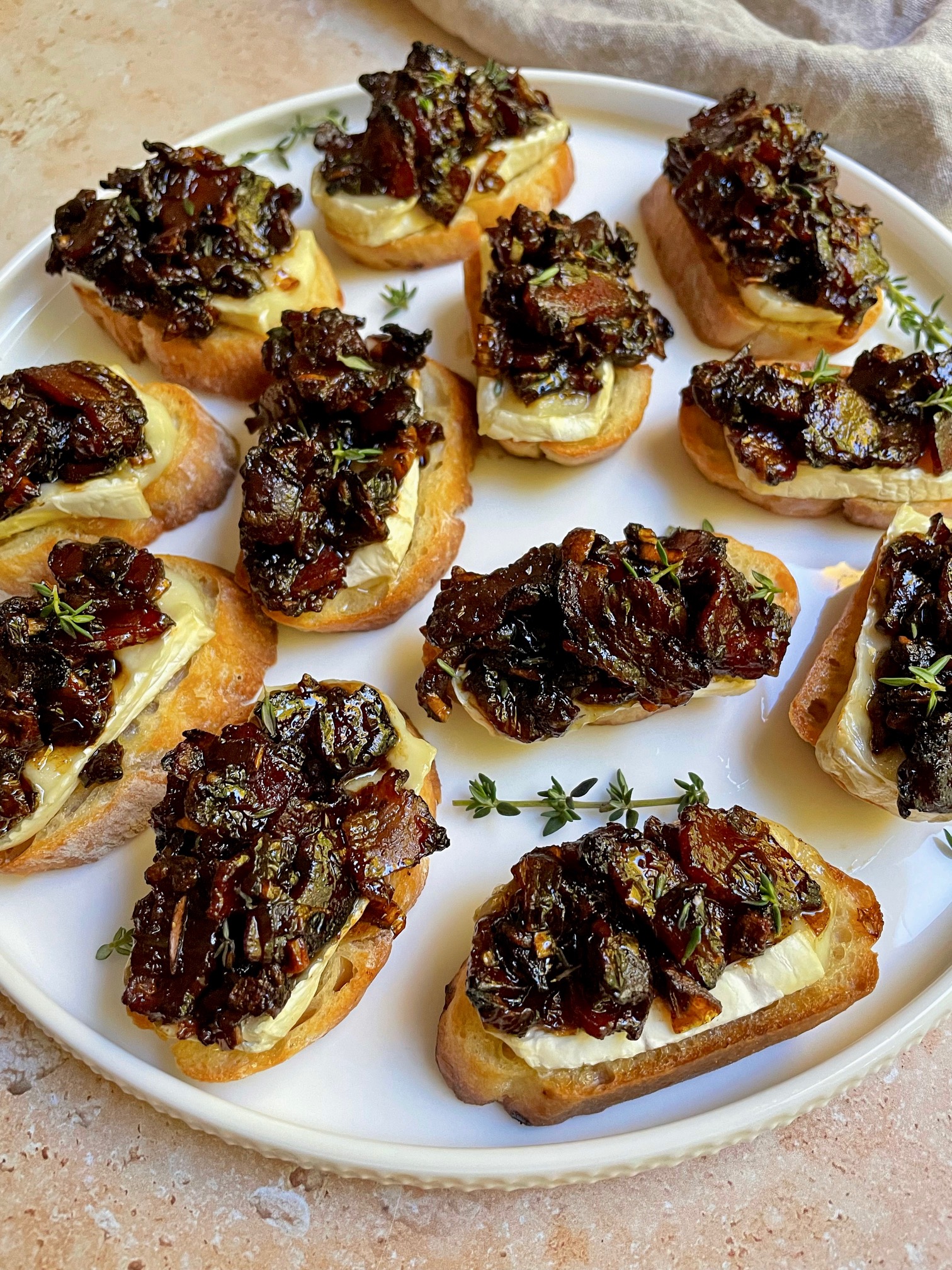 brie and bacon jam crostini on a plate.
