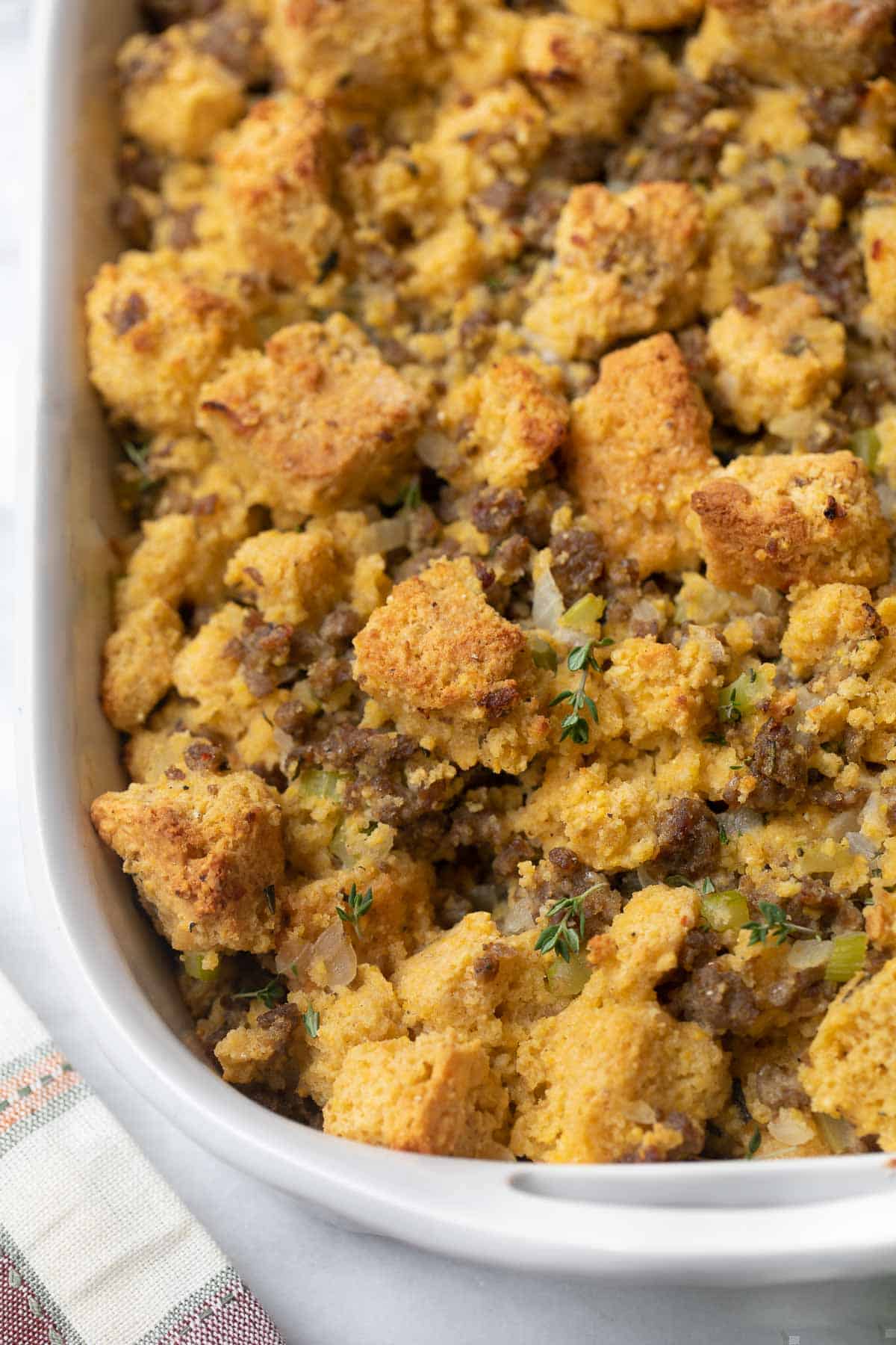 A close up of gluten free cornbread stuffing in a baking dish.