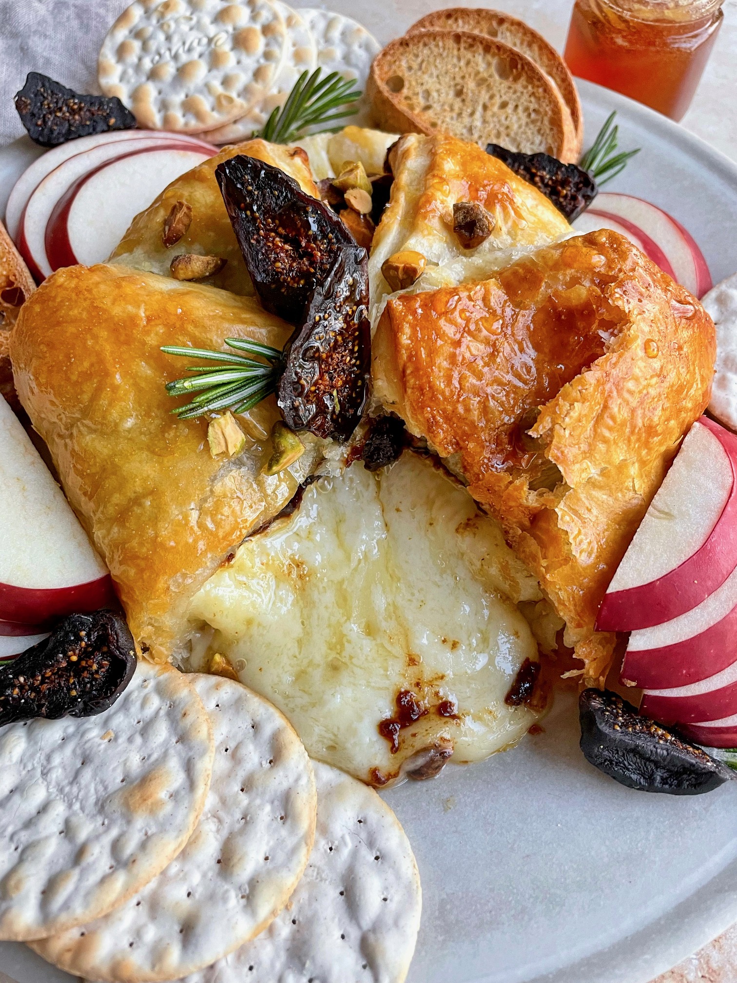 baked brie with a slice cut out to show the melty brie inside.
