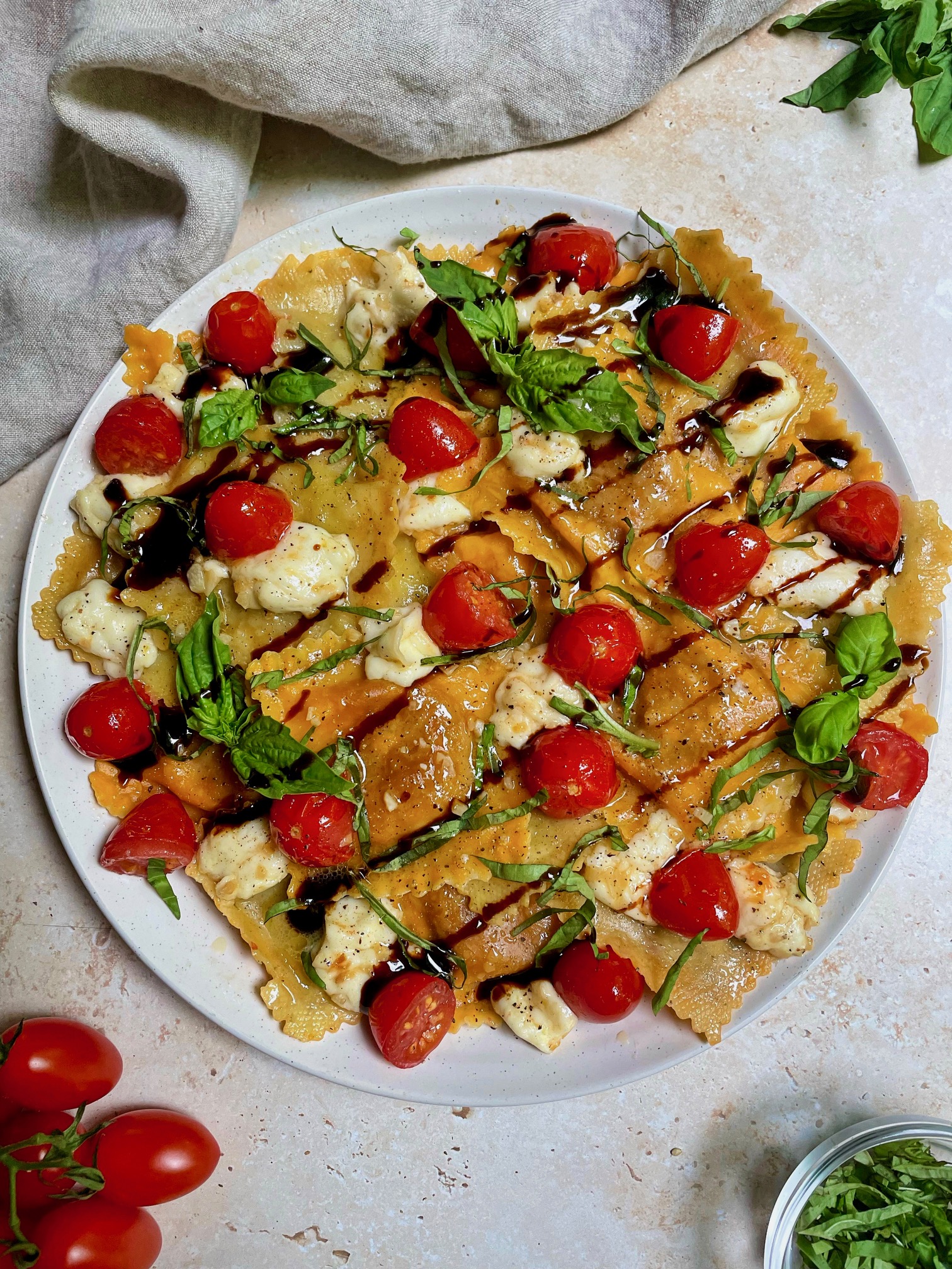 The finished plated caprese ravioli with a balsamic glaze drizzle.