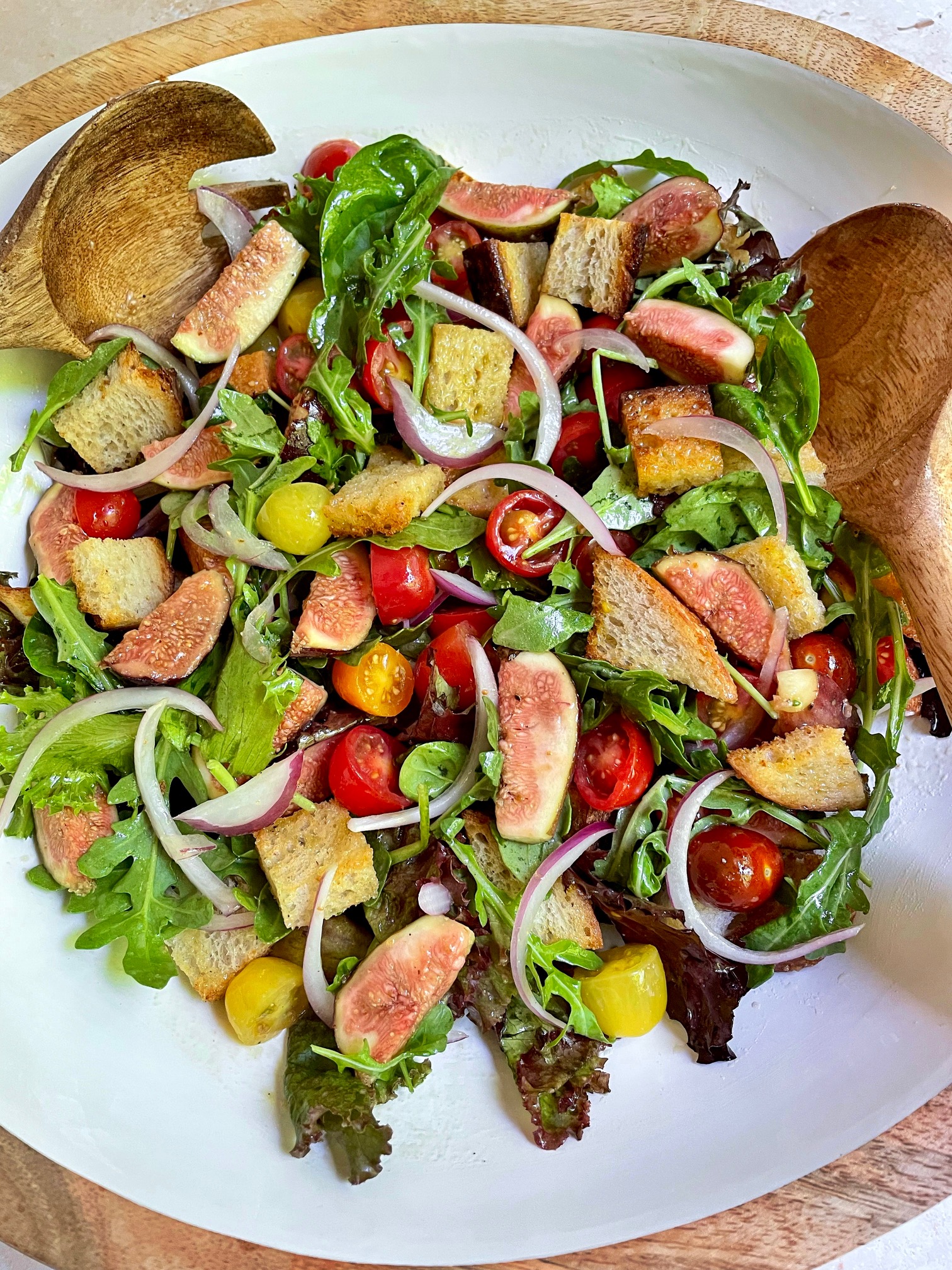 Fig Panzanella Salad in a big serving bowl with serving utensils.