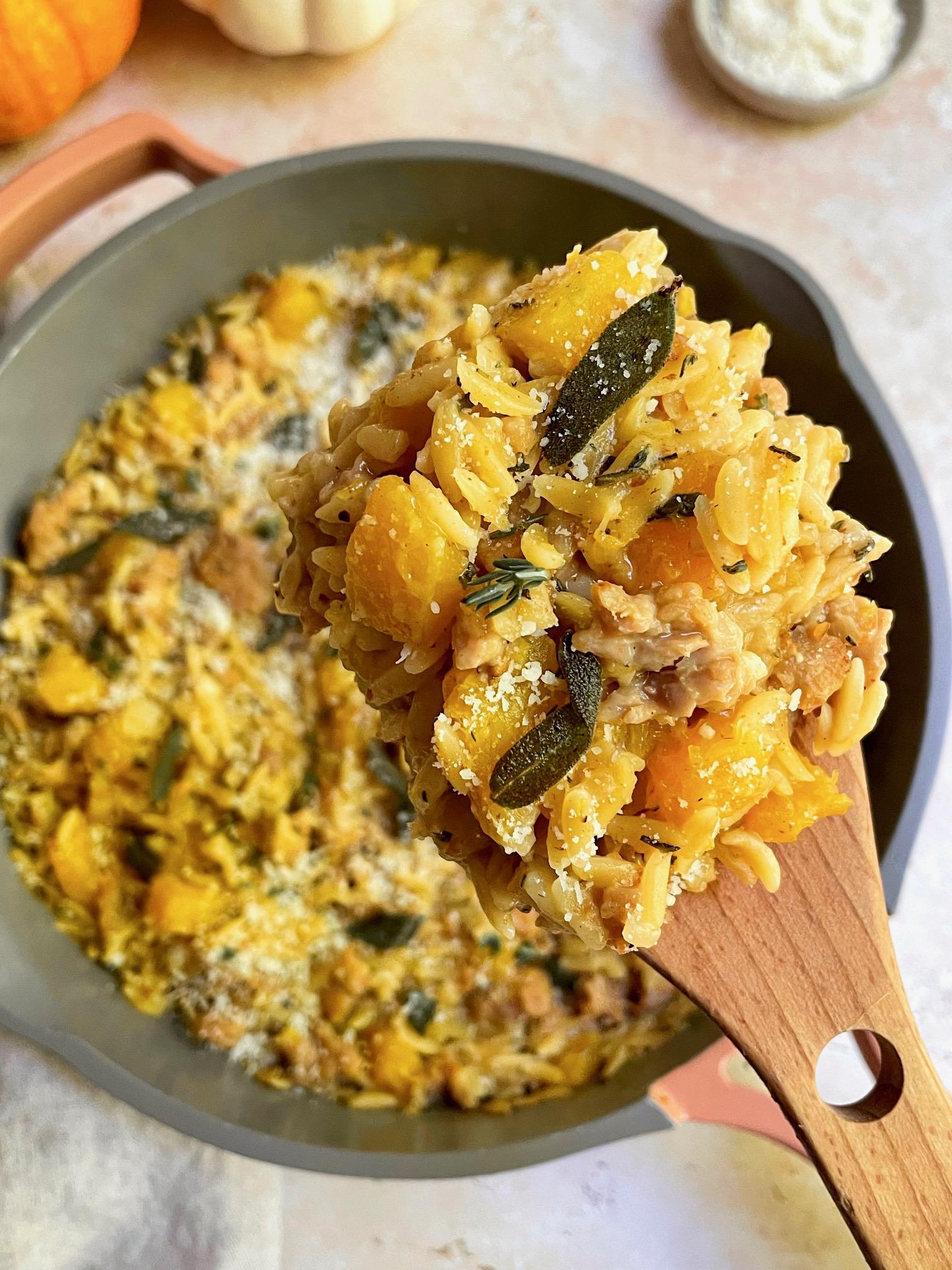 Some of the butternut squash sausage orzo on a serving spoon close up.