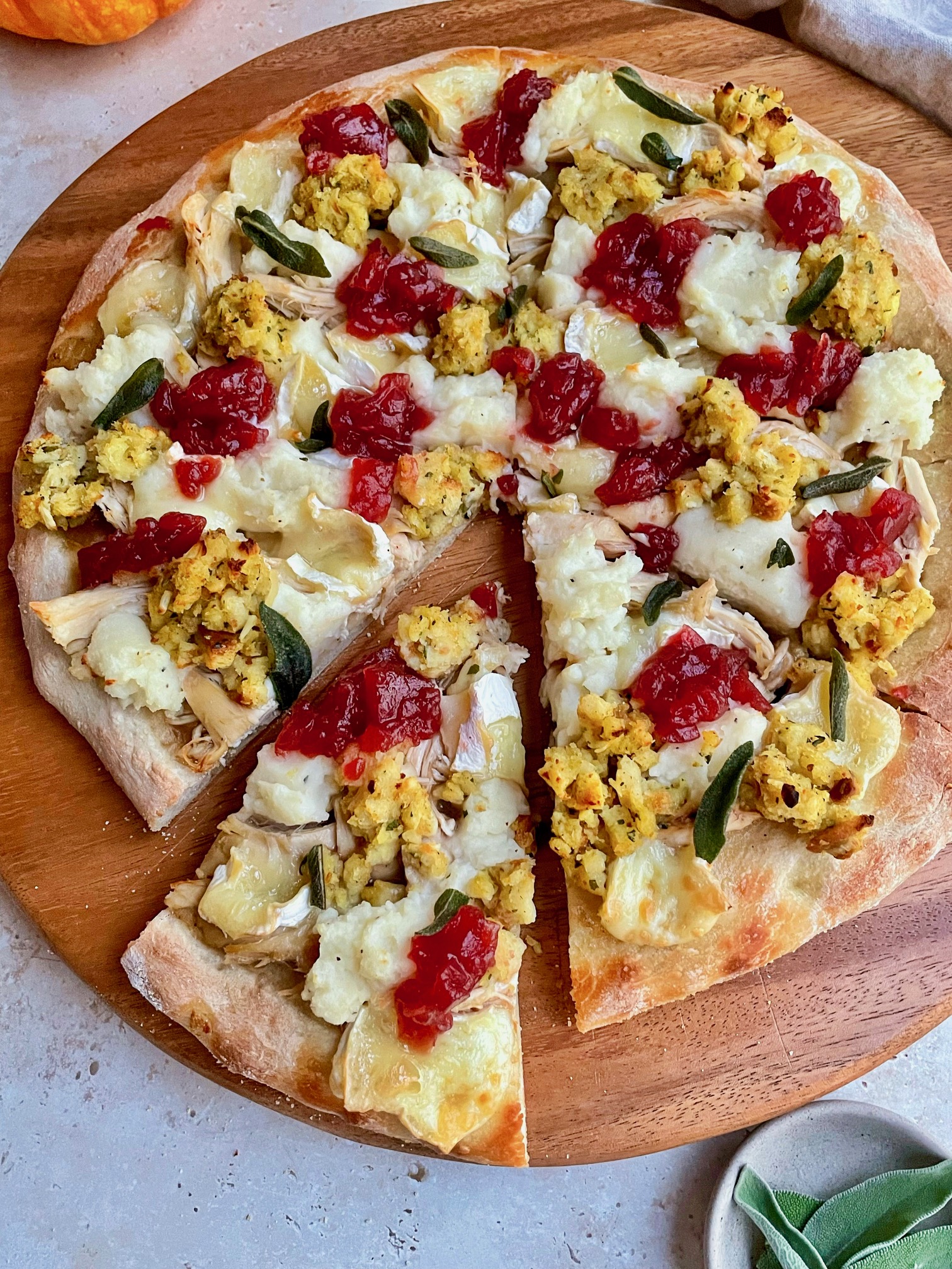 The Thanksgiving pizza on a wooden cutting board.