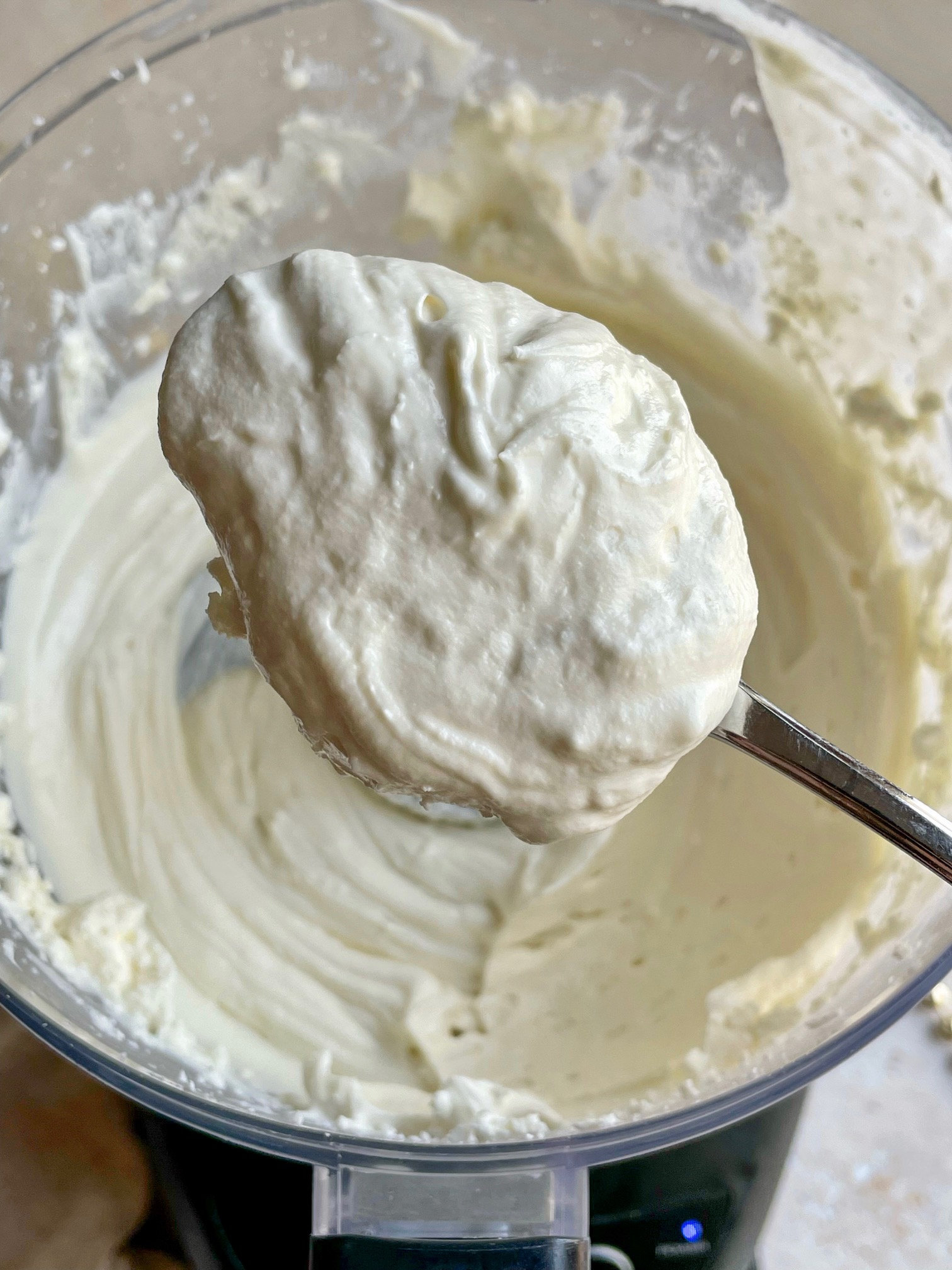 A spoonful of whipped goat cheese out of the food processor to show texture.