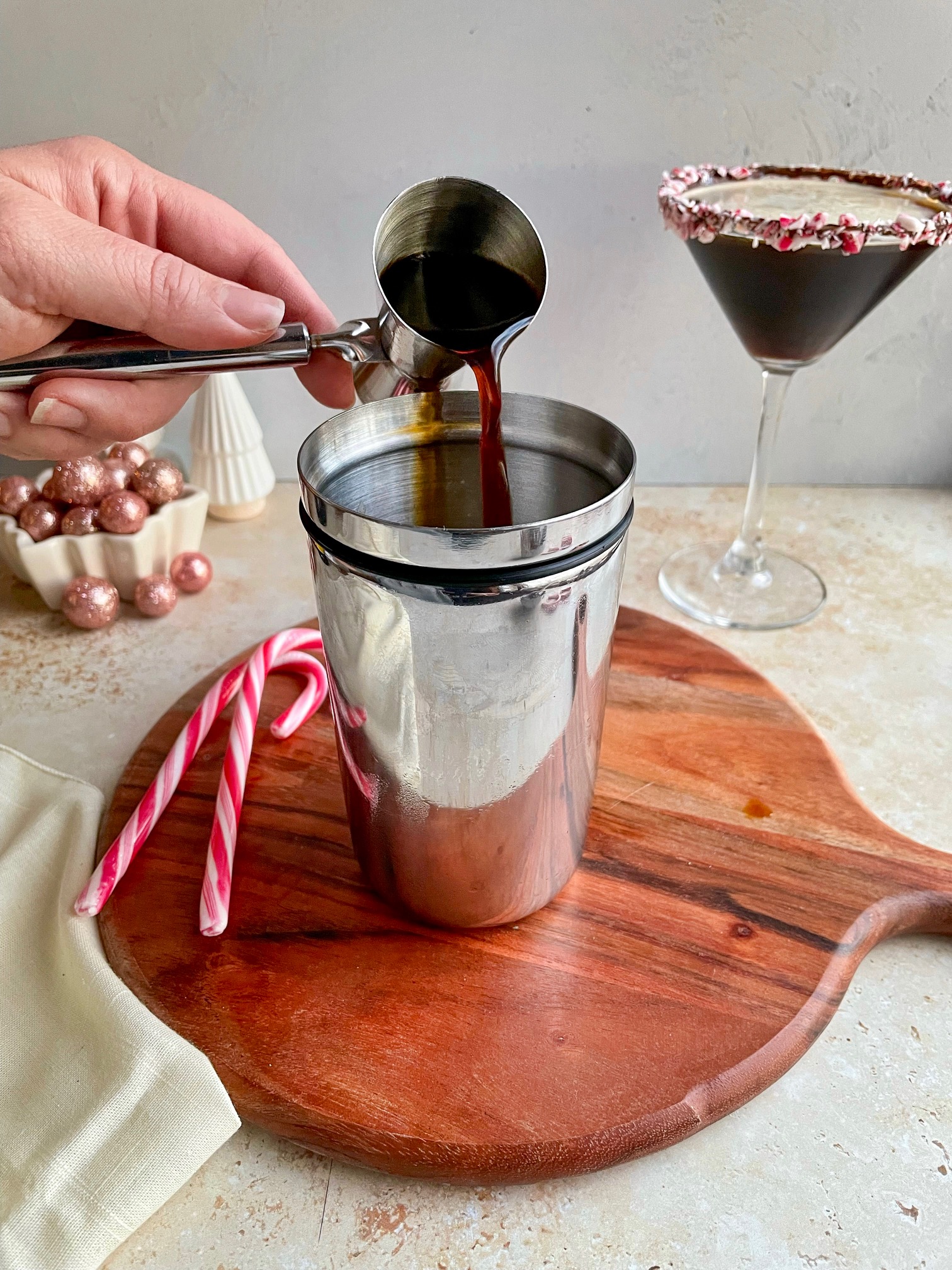 Pouring espresso into a cocktail shaker with ice.