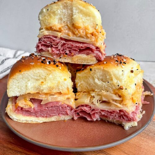 A reuben slider stacked on top of two reuben sliders.