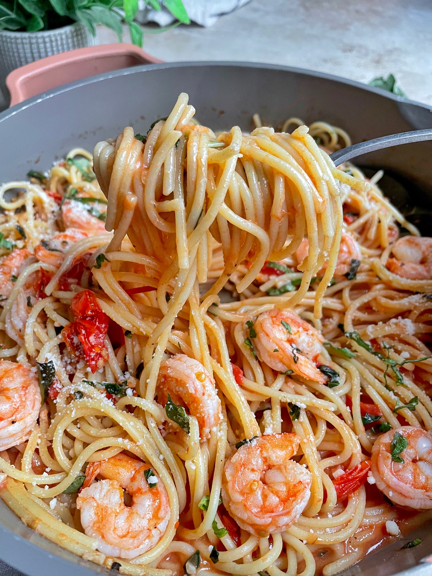 A fork lifting a twirl of spaghetti out of the pan.