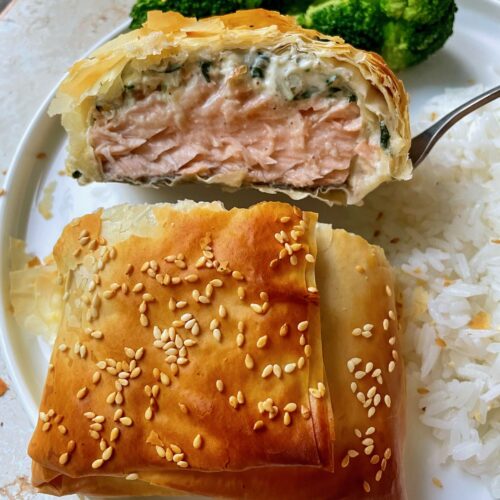 The cross section of spinach feta salmon in phyllo to show flaky top and inside layers.