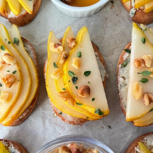 A close up of pear, blue cheese and honey crostini.