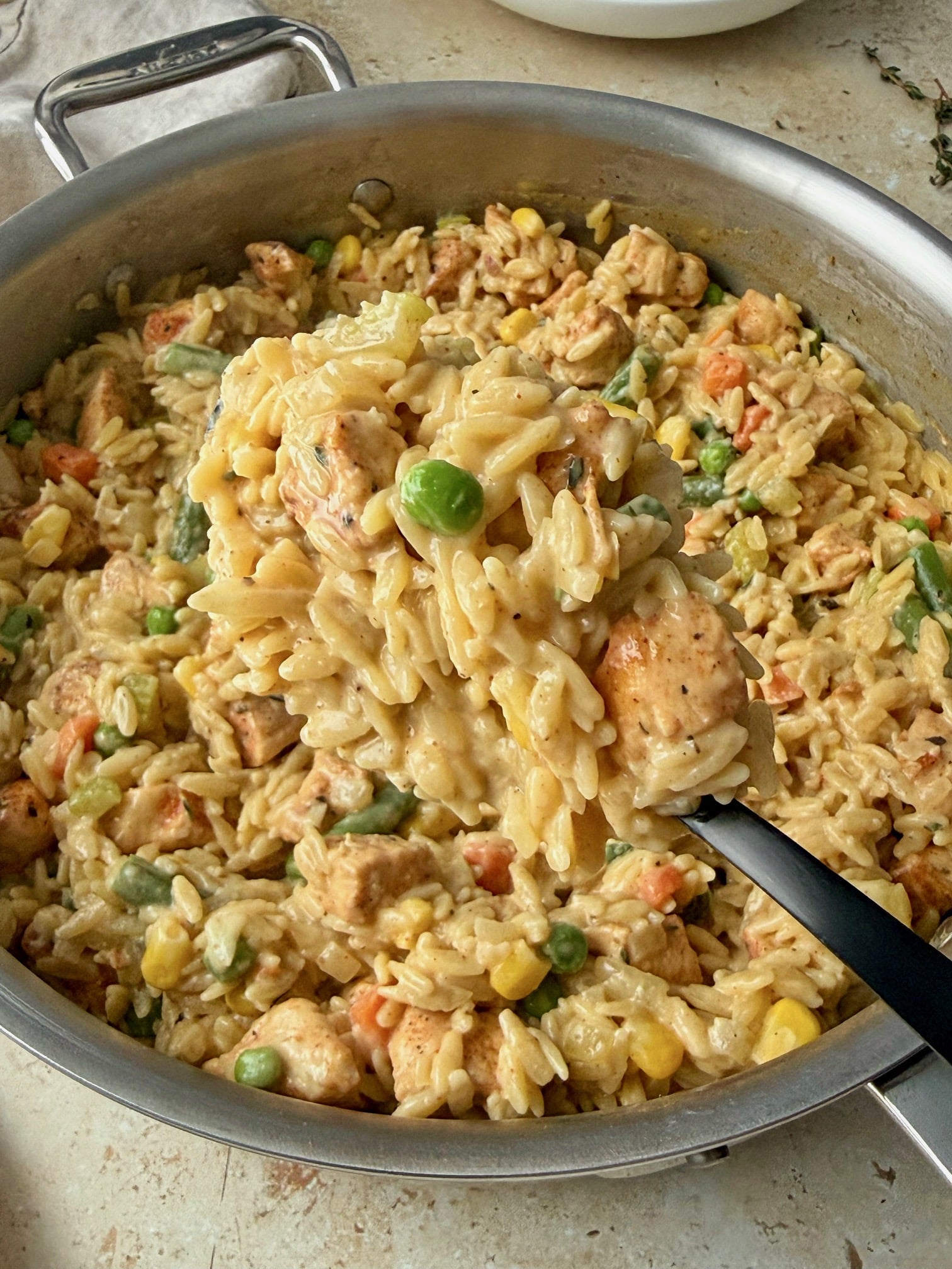 A close up of orzo on a serving spoon to show texture.