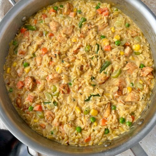 Overhead shot of chicken pot pie orzo in a large skillet.