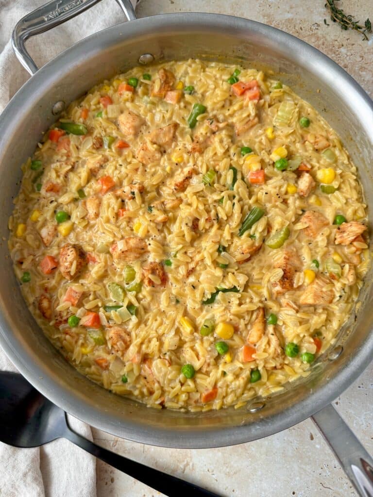 Overhead shot of chicken pot pie orzo in a large skillet.