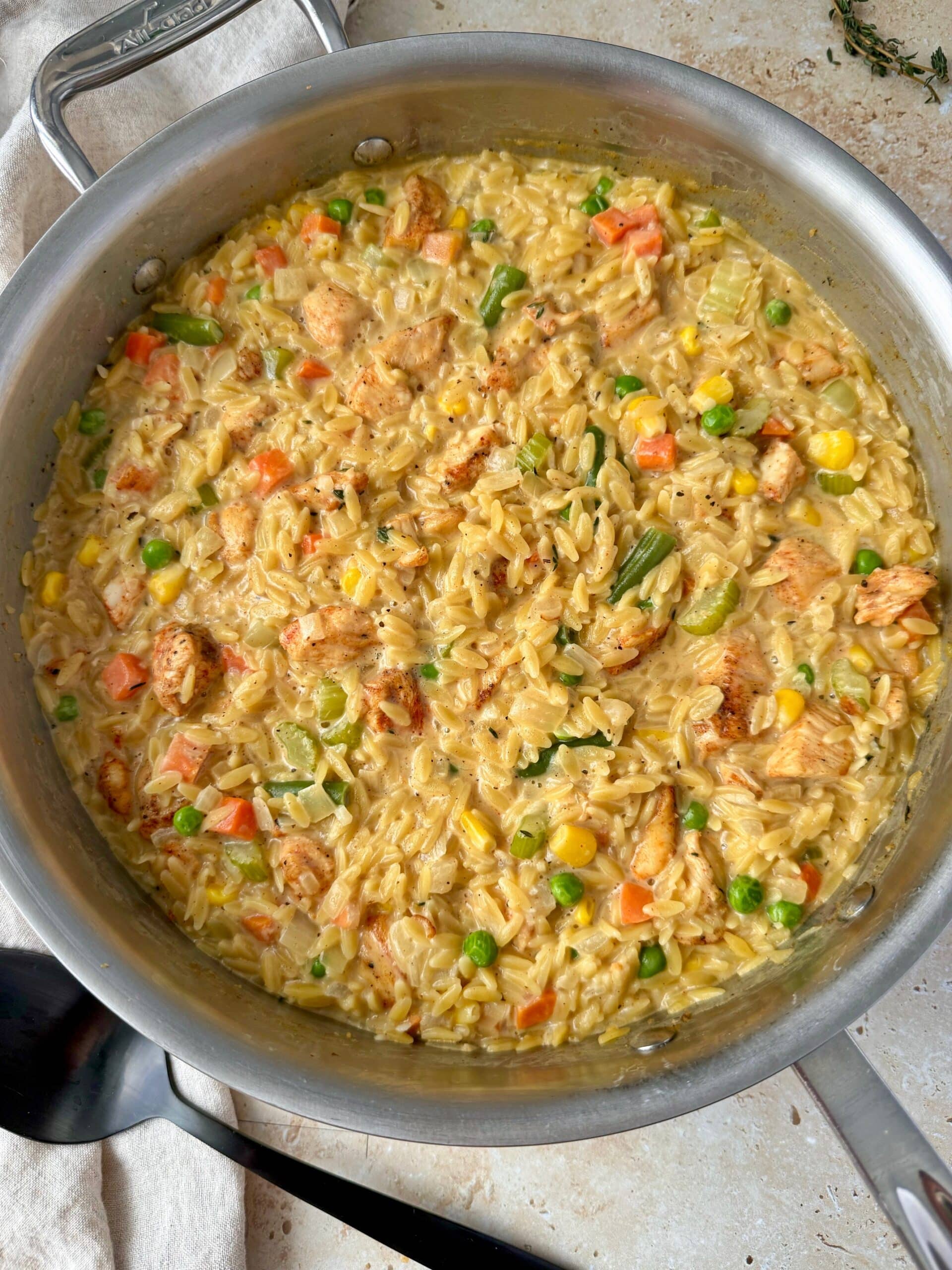 Overhead shot of chicken pot pie orzo in a large skillet.