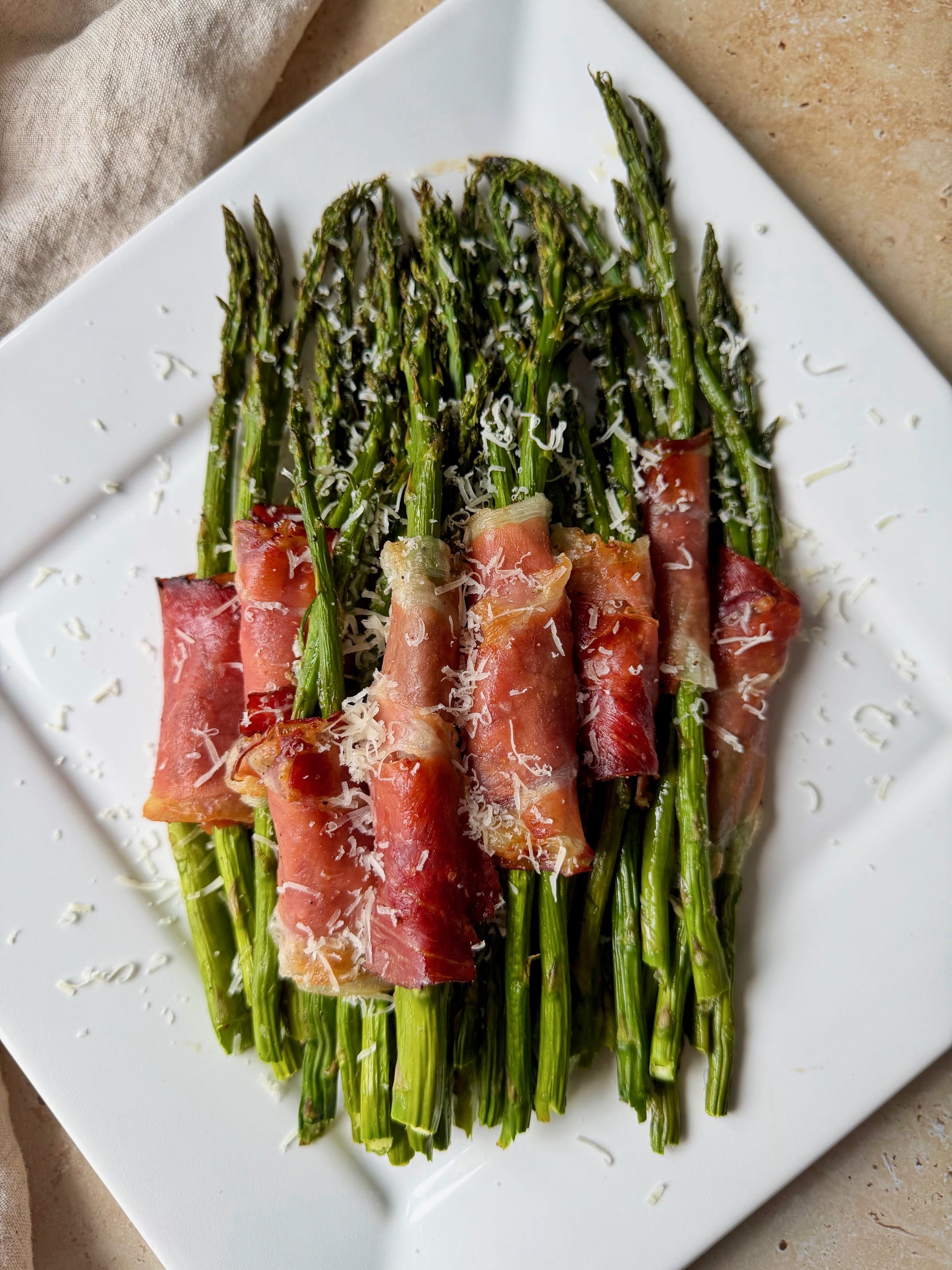 An overhead photo of the final dish on a platter with shredded parmesan cheese on top.