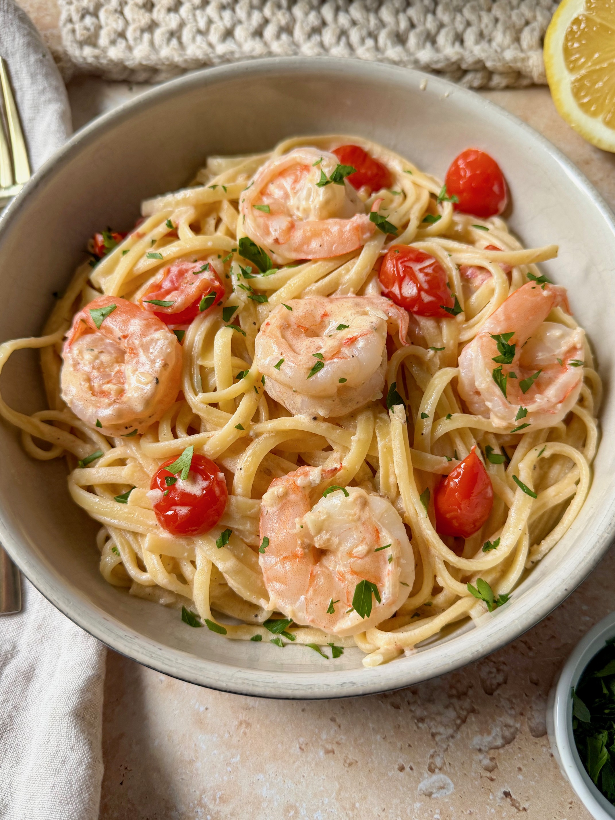 A close up picture of creamy lemon garlic shrimp pasta in a bowl.