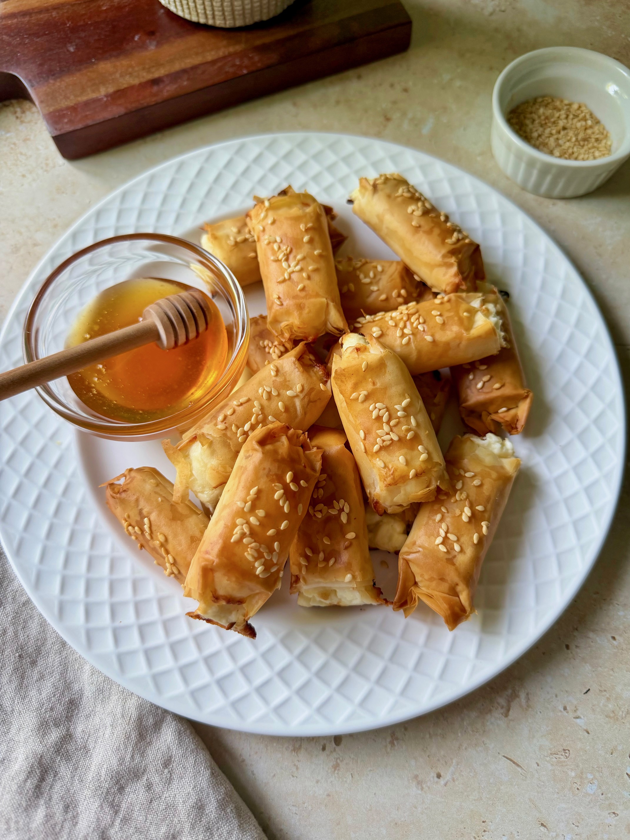 Feta phyllo rolls on a plate with honey.