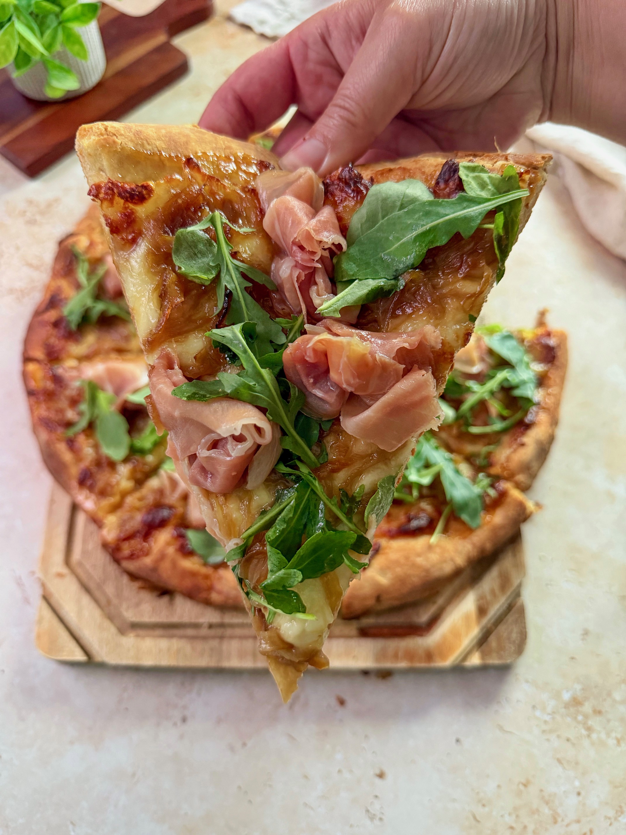 A close up of a slice of fig prosciutto pizza.
