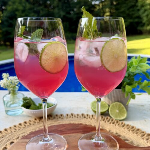 Two Sarti spritz garnished with lime and mint.